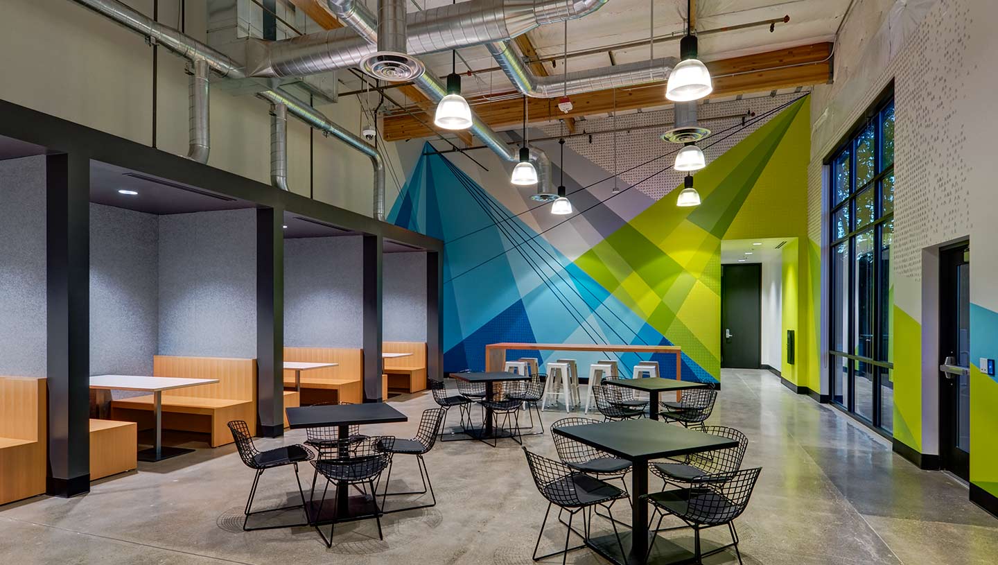 Dining area in headquarters illuminated by Prisma pendent luminaries