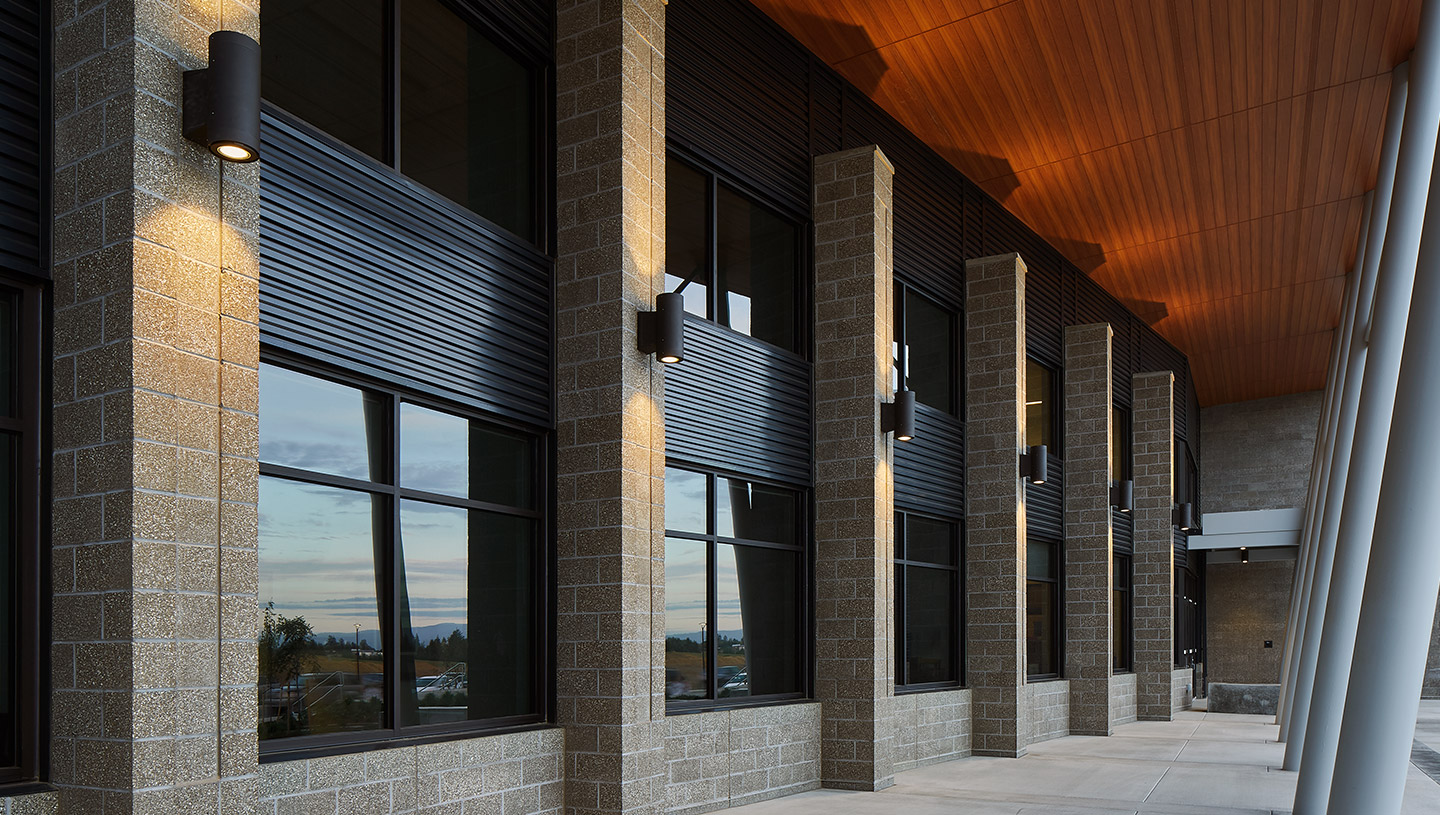 Syrios Pro luminaires with up and downlight on exterior columns of building